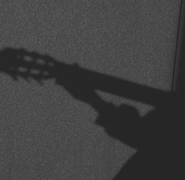 Silueta de una guitarra clásica de seis cuerdas en blanco y negro.