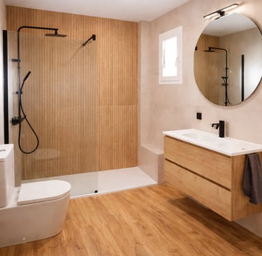 Reforma de baño moderno con plato de ducha a ras y mampara fija en Sevilla