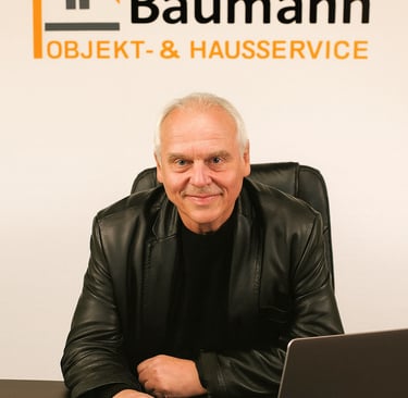 Seniorchef Herr Baumann von Baumann Objekt- & Hausservice sitzt am Schreibtisch
