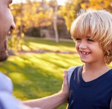 padre despidindo a su hijo en un campamento