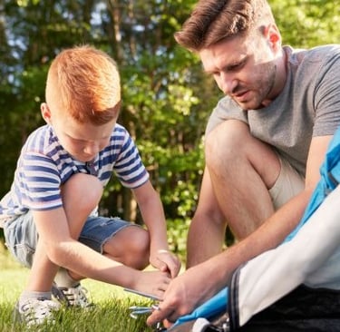 padre e hijo montando una tienda de campaña