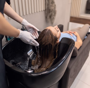 a woman getting her hair washed with a hair dryer