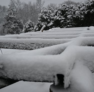 Airstream Trailer frame covered in snow in front of snow covered tree line