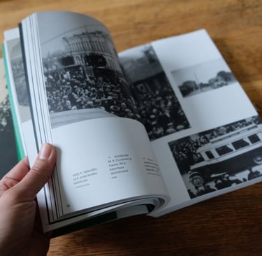 The photo shows the pages of a book being turned. Vintage photos are visible.