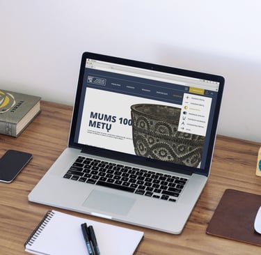 A laptop with the front page of the museum's website is open.