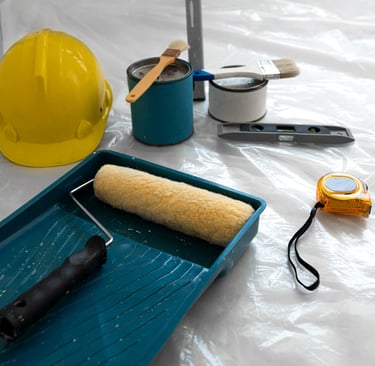 a paint roller painting a blue tray of paint