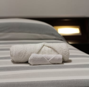 lodgings in sardinia a folded towel on a bed with a folded towel