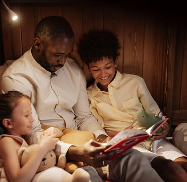 a man and two children reading a book