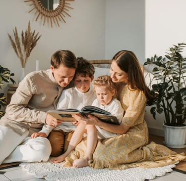 a family of two children sitting on a rug