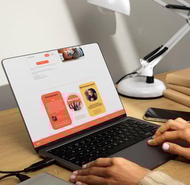 une personne assise à un bureau avec un ordinateur portable et un téléphone