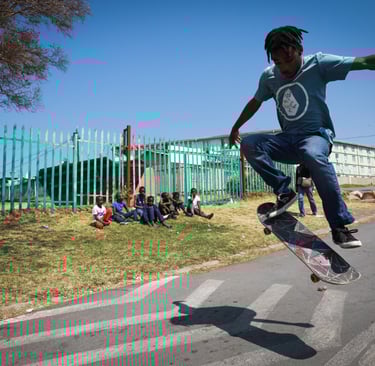 a man in a blue shirt is doing a trick on a skateboard