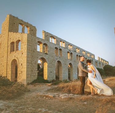 una sposa e uno sposo in piedi davanti a un edificio in pietra in Sicilia
