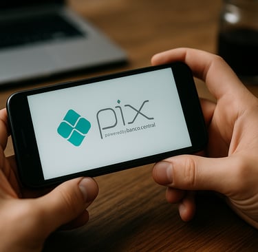 Pessoa segurando um smartphone que exibe a logo do Pix na tela, com fundo desfocado mostrando uma me