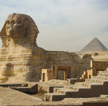 The Great Sphinx and pyramids at Giza under a clear blue sky.