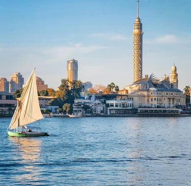 Traditional felucca sailboat on the Nile River with Cairo Tower in the background.