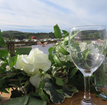 Elegant outdoor wedding table setting with white roses, greenery, and a wine glass. Dordogne