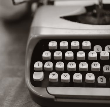 An angled, black and white image of a typewriter