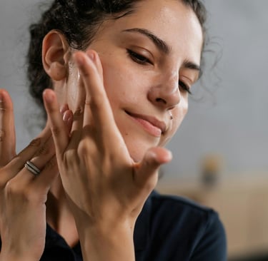 jeune femme qui mets de la creme sur son visage