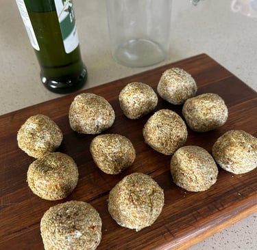Labneh balls rolled in herbs on a wooden board
