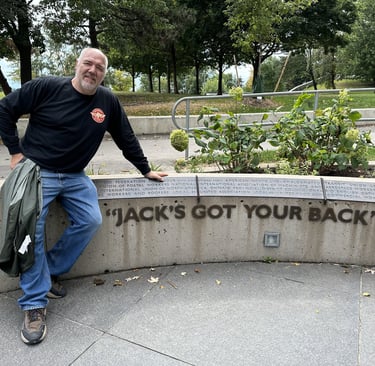 jack wozniak jeaning on a sign stating "jack's got your back"