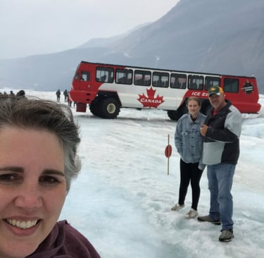 trish wozniak standing on an icefiel with her husband and daughter in the background