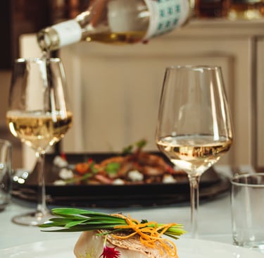 Filetto di pesce bianco su letto di verdure, con erba cipollina e fiori, servito con vino bianco