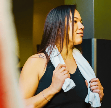 Cooling towel draped around woman's neck at a gym