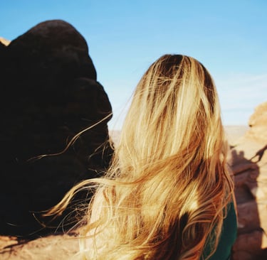 lady with blonde hair looking out over the mountains