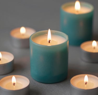 An elegant aroma jar candle surrounded by rose red and sandalwood brown accents.