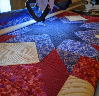 a patriotic quilt being stitched on a longarm machine