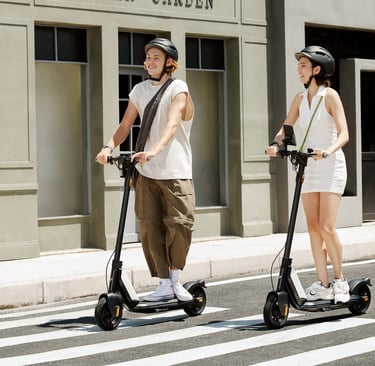 two people standing on a street with scooters