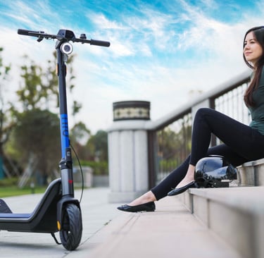 a woman sitting on a ledge with a scooter