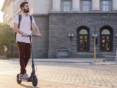 a man riding a scooter on a city street