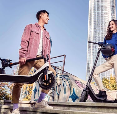 a man and woman standing on stairs with a scooter