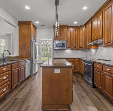 Modern kitchen with cherry wood cabinets, granite countertops, and stainless steel appliances.