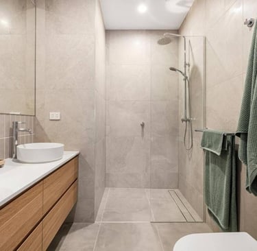 a bathroom with a toilet and a sink rainwater shower two basin luxury ensuite
