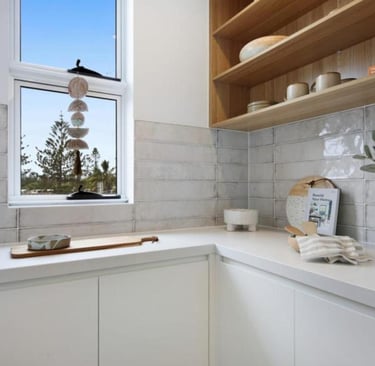 a butlers pantry with a window and a vase with flowers