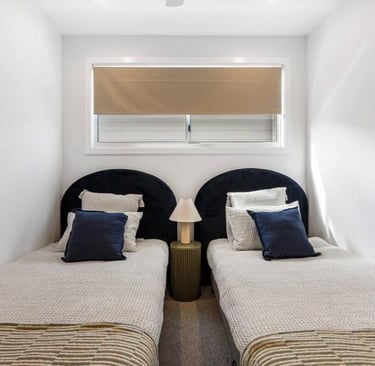 two twin beds in a room with a window