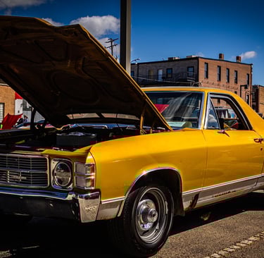 a yellow car with a hood up and a hood up