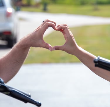 a man and woman making a heart shape with their hands