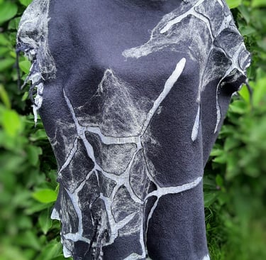 Handmade nuno felted wool tunic in charcoal gray with white web design on a dress form.