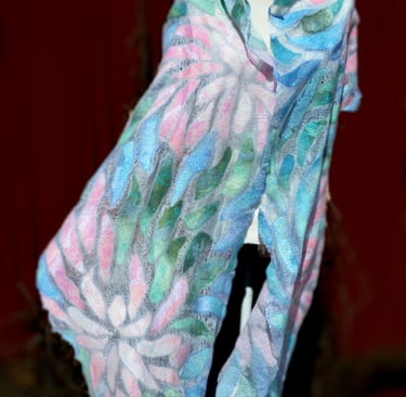 Handmade nuno felted scarf with pastel floral patterns in pink, blue, and green on a white silk base.