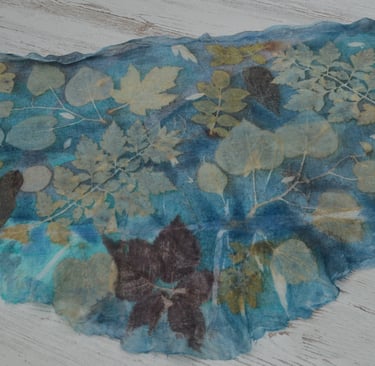 Blue leaves printed silk scarf featuring botanical leaf impressions in natural earthy tones.