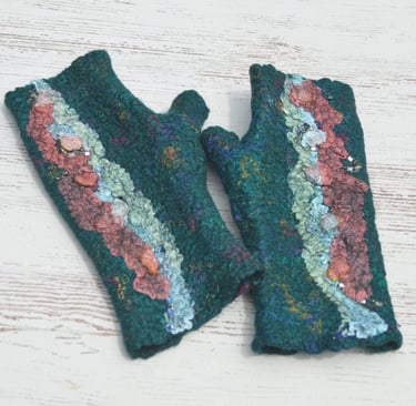 Handmade emerald green felted wool fingerless gloves with colorful textured fiber art details.
