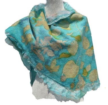 Handmade turquoise nuno felted wool scarf with white floral leaf patterns and ruffled edges.