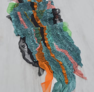 Handmade nuno felt scarf featuring layered green silk and vibrant orange silk ruffles