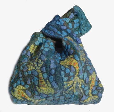 Handmade nuno felted bag with blue and green mosaic wool patterns and a unique knot closure.