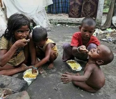 a group of children eating food in a makeshift shelter in Africa