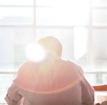 a person sitting at a table with a laptop