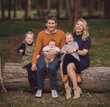 a family of five sitting on a log log